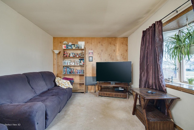 carpeted living room with wood walls