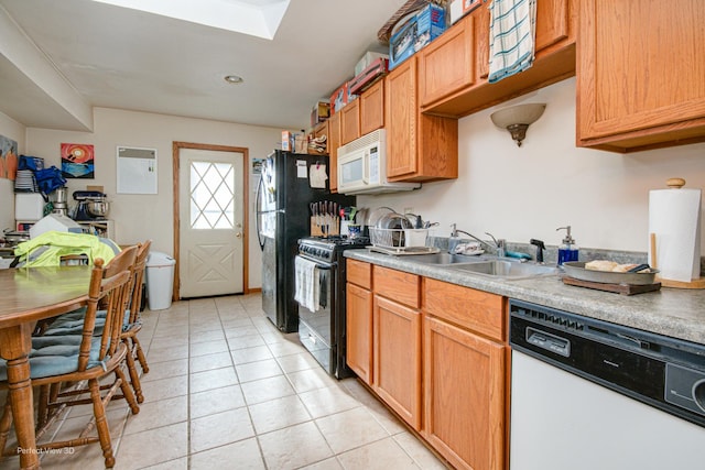 kitchen with sink, light tile patterned flooring, and black appliances