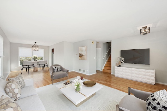 living room with a chandelier and light wood-type flooring