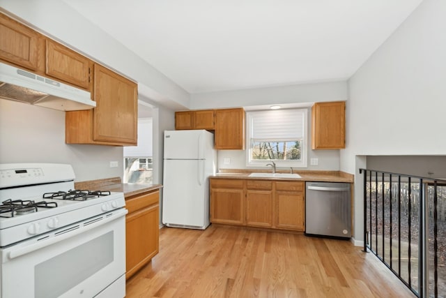 kitchen featuring light wood-type flooring, white appliances, and sink