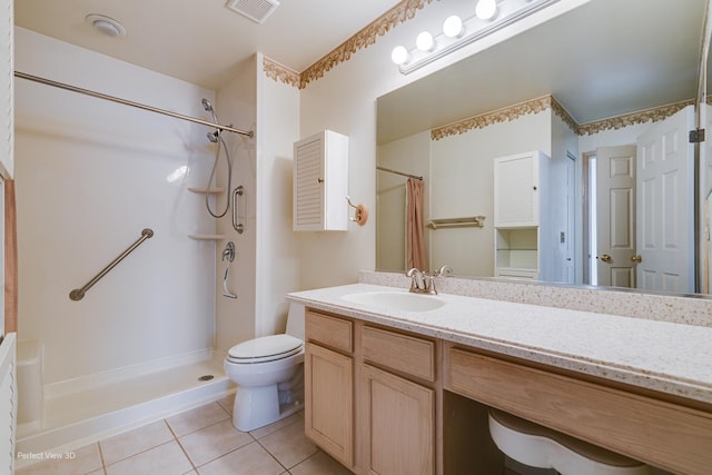 bathroom featuring toilet, tile patterned flooring, vanity, and walk in shower