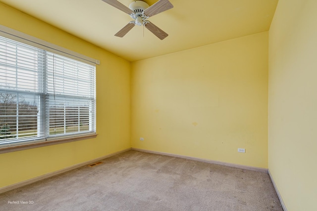 carpeted spare room featuring ceiling fan