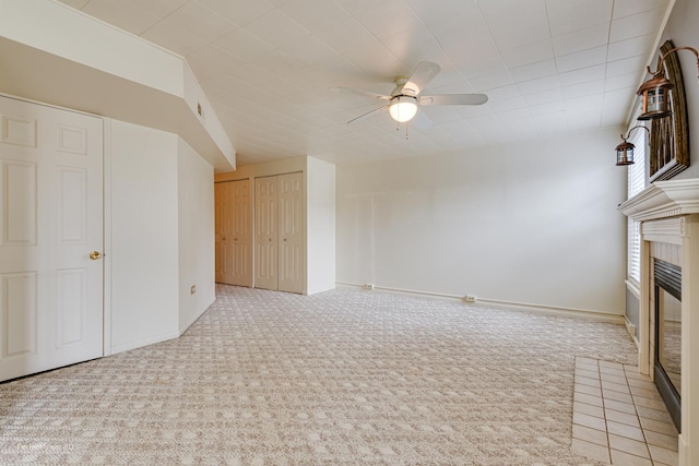 unfurnished living room featuring ceiling fan and light colored carpet