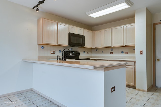 kitchen with black appliances, light tile patterned flooring, kitchen peninsula, and tasteful backsplash