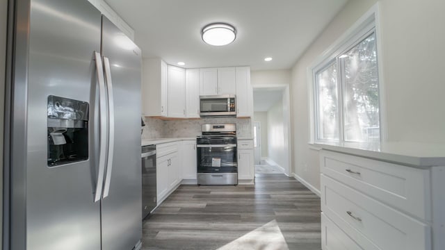 kitchen with backsplash, white cabinetry, dark wood-type flooring, and appliances with stainless steel finishes