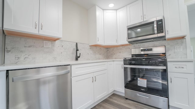 kitchen featuring white cabinetry, stainless steel appliances, and light hardwood / wood-style floors