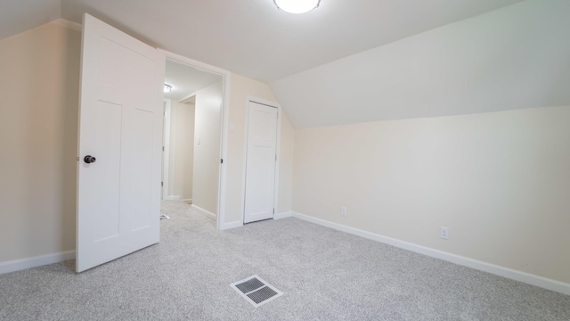 bonus room with light colored carpet and lofted ceiling