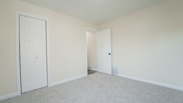 unfurnished bedroom featuring carpet flooring and a closet