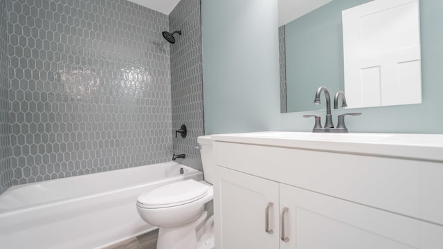 full bathroom with vanity, hardwood / wood-style floors, tiled shower / bath combo, and toilet