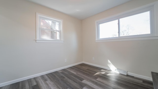 unfurnished room with plenty of natural light and dark hardwood / wood-style flooring