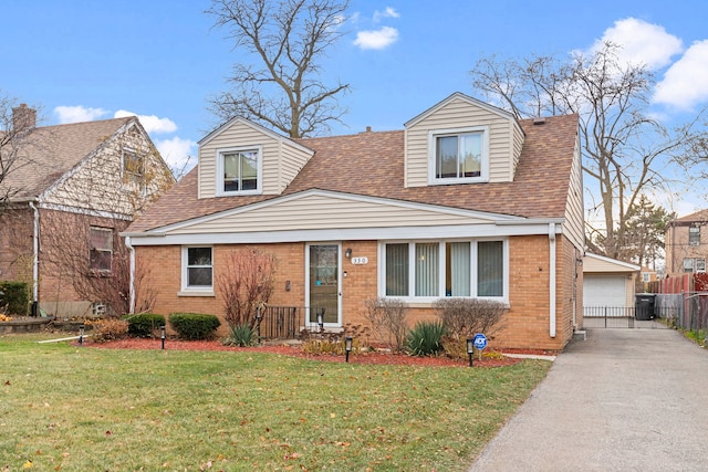 new england style home with a front yard and a garage