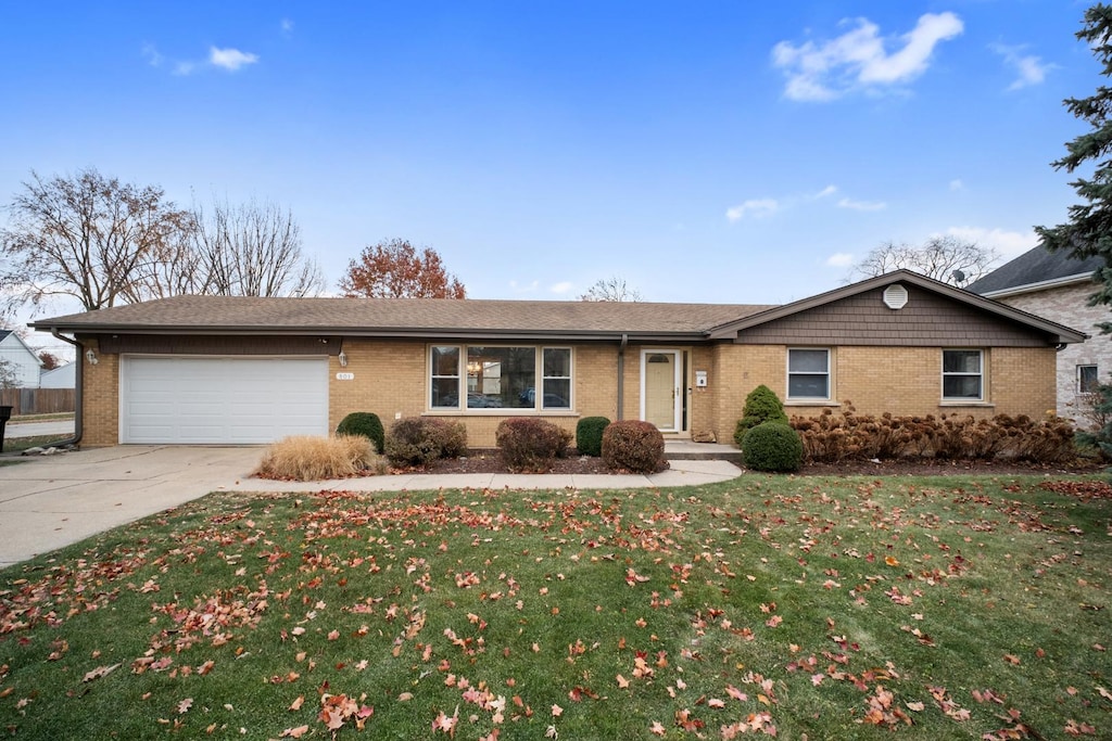 ranch-style home with a front lawn and a garage