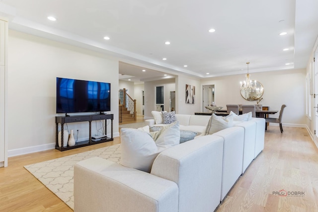 living room featuring a chandelier and light hardwood / wood-style flooring