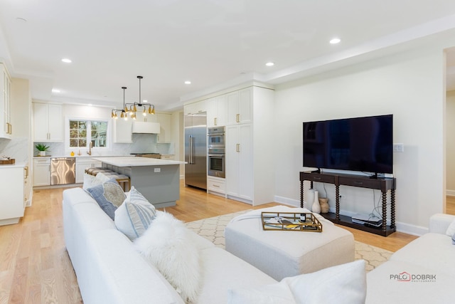 living room featuring sink and light hardwood / wood-style flooring