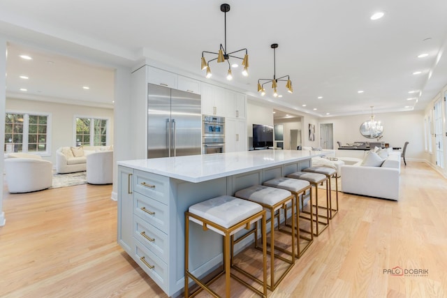 kitchen featuring pendant lighting, an inviting chandelier, a spacious island, and appliances with stainless steel finishes