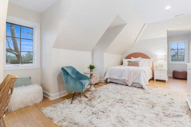 bedroom featuring vaulted ceiling and light wood-type flooring