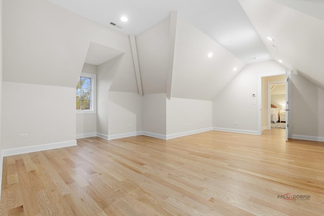 bonus room with vaulted ceiling and light hardwood / wood-style flooring