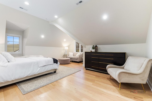 bedroom with vaulted ceiling and light hardwood / wood-style floors