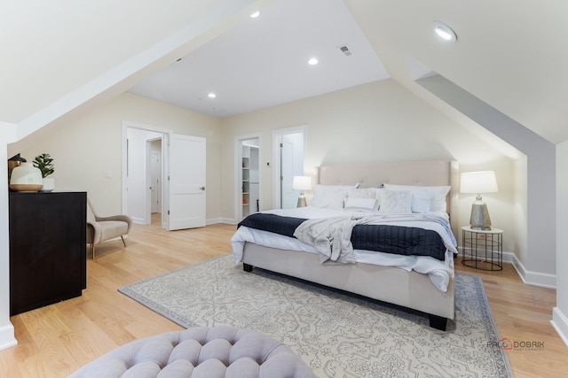 bedroom featuring vaulted ceiling and light hardwood / wood-style flooring