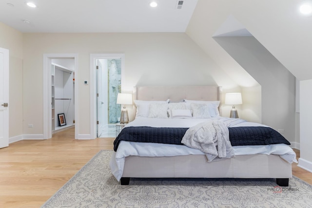 bedroom featuring vaulted ceiling and light wood-type flooring