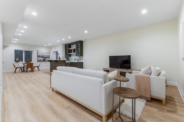 living room with bar area and light hardwood / wood-style floors