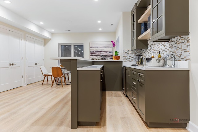 kitchen featuring tasteful backsplash, a kitchen bar, and light hardwood / wood-style flooring