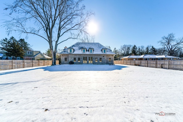 view of snow covered rear of property