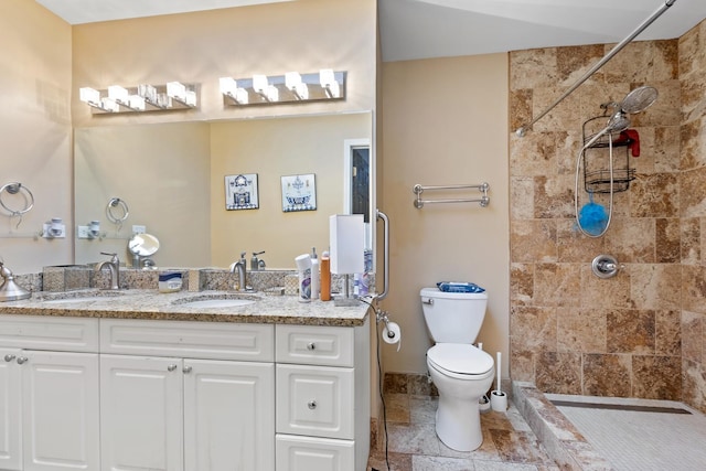 bathroom with vanity, toilet, and a tile shower