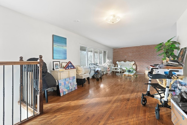 interior space with hardwood / wood-style floors and brick wall