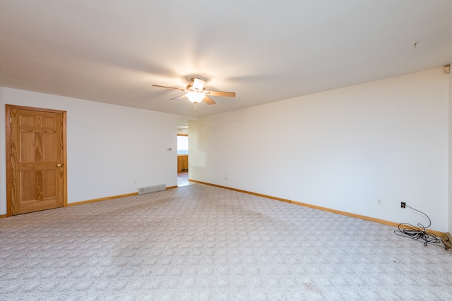 carpeted spare room with ceiling fan