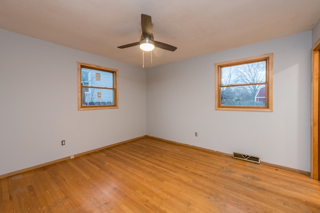 empty room with ceiling fan and light hardwood / wood-style flooring