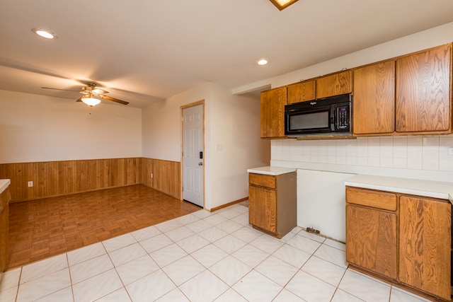 kitchen featuring backsplash, ceiling fan, light parquet floors, and wood walls