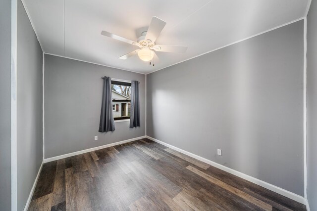 spare room with crown molding, ceiling fan, and dark wood-type flooring