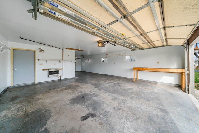 garage featuring heating unit and a garage door opener