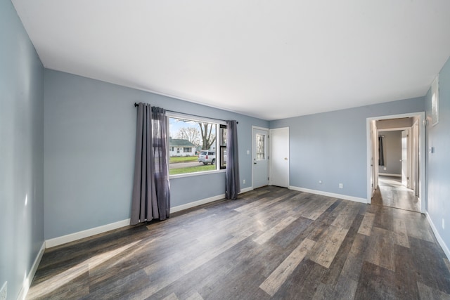 unfurnished room with dark hardwood / wood-style flooring