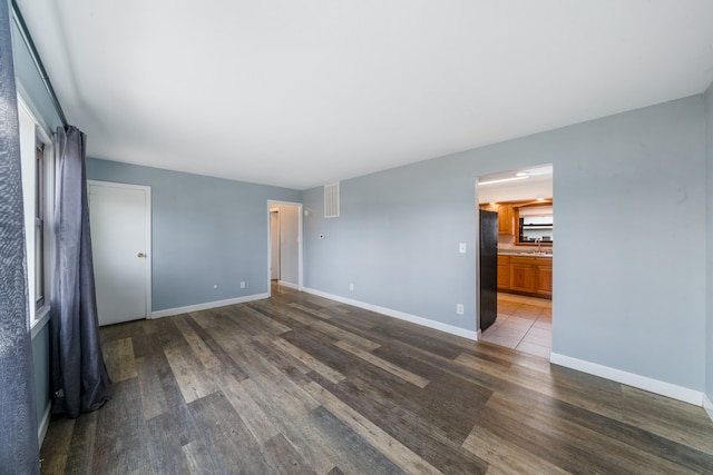 unfurnished room featuring dark hardwood / wood-style flooring and sink