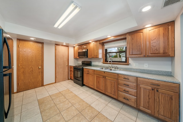 kitchen featuring black appliances, light tile patterned flooring, and sink