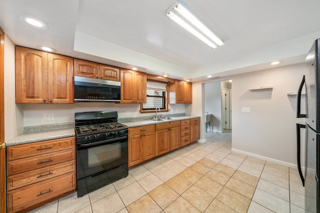 kitchen featuring refrigerator, sink, light tile patterned floors, and black gas range oven