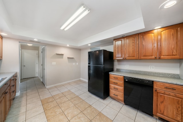 kitchen featuring black appliances, light tile patterned flooring, and a tray ceiling