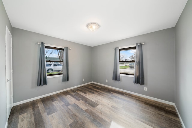 empty room featuring a healthy amount of sunlight and dark hardwood / wood-style flooring