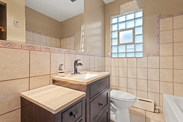 bathroom with a washtub, vanity, baseboard heating, tile walls, and toilet