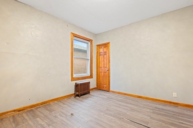 empty room featuring light hardwood / wood-style floors and radiator heating unit