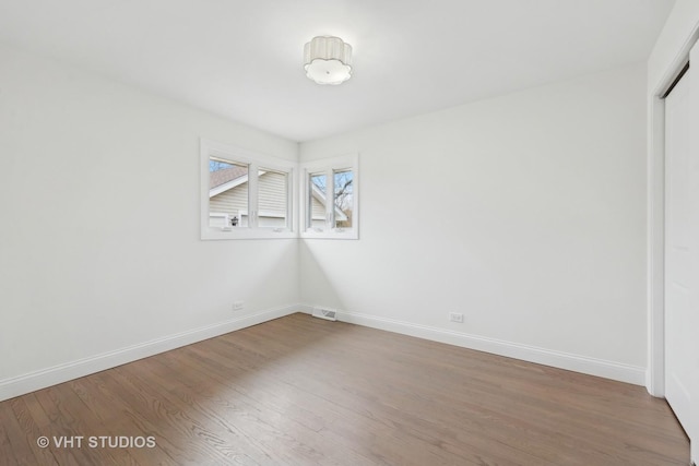 empty room with hardwood / wood-style flooring