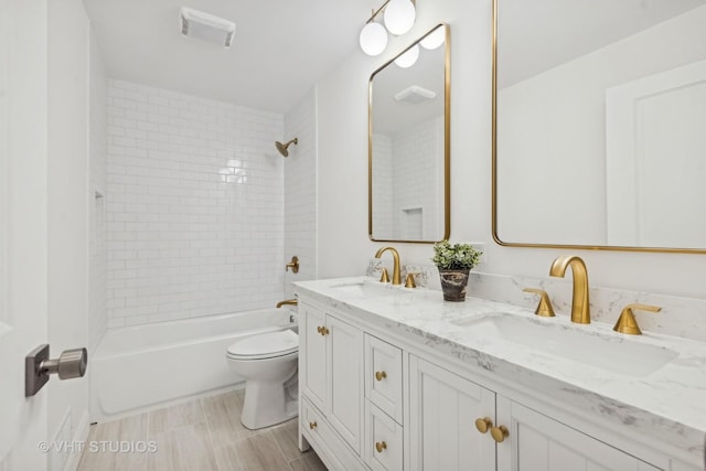 full bathroom with vanity, toilet, and tiled shower / bath