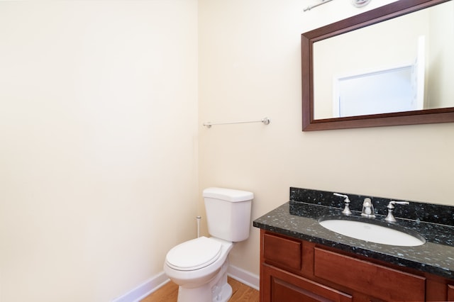 bathroom with hardwood / wood-style flooring, vanity, and toilet