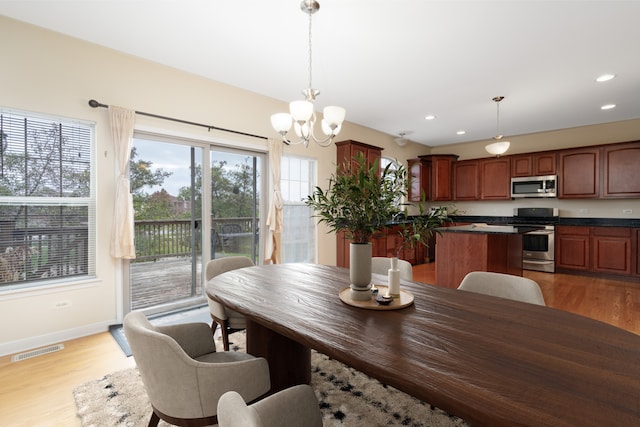 dining room featuring a notable chandelier and light wood-type flooring