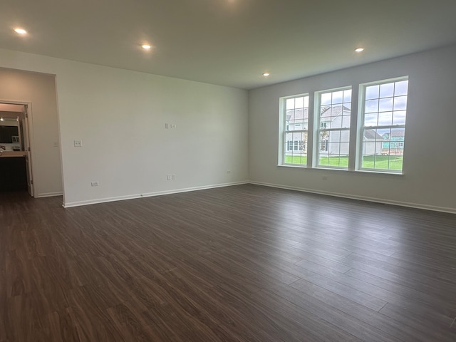 spare room with dark wood-type flooring