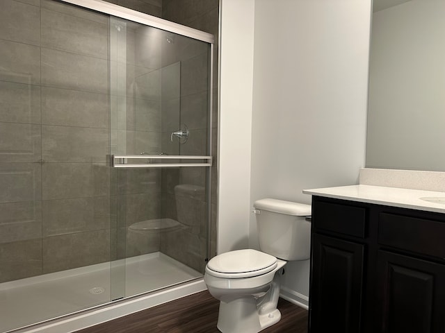 bathroom featuring hardwood / wood-style floors, vanity, toilet, and walk in shower