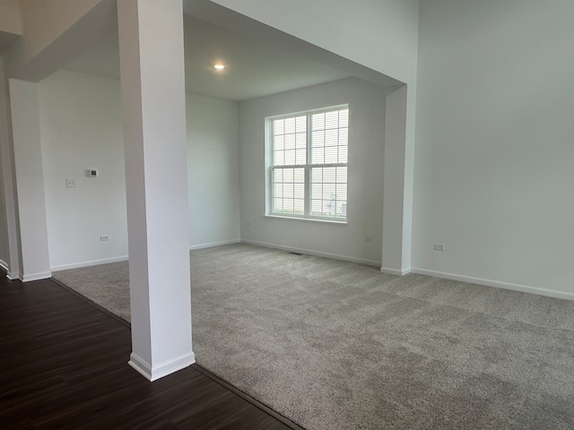 unfurnished room with dark carpet