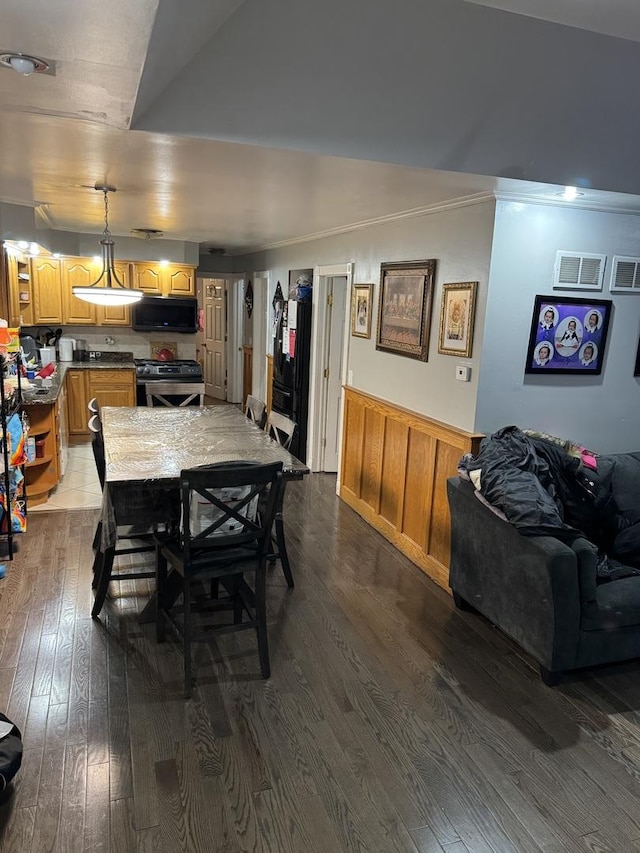 dining space featuring crown molding and dark hardwood / wood-style flooring